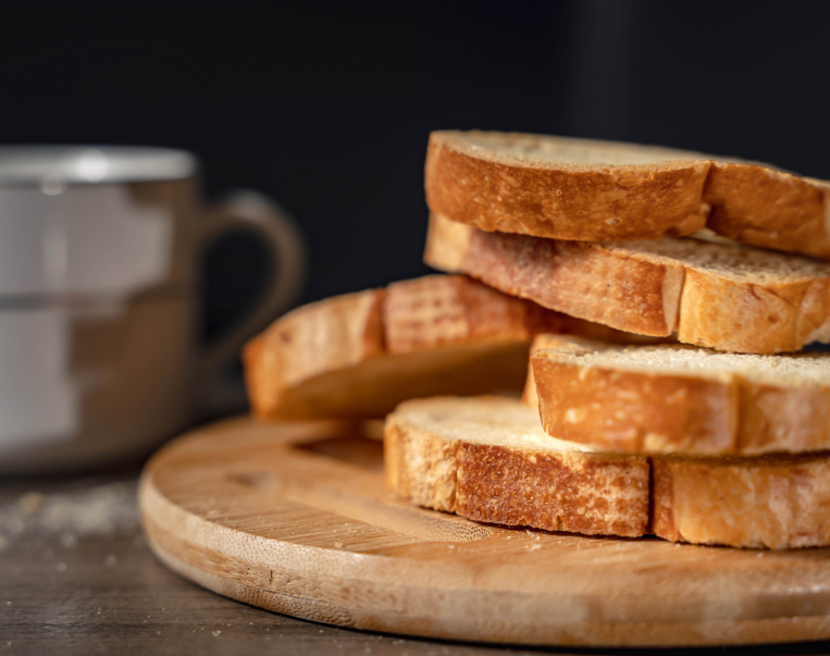 bread for breakfast, with cup of coffee over rustic wooden background with copy space. Morning breakfast with coffee and toasts.